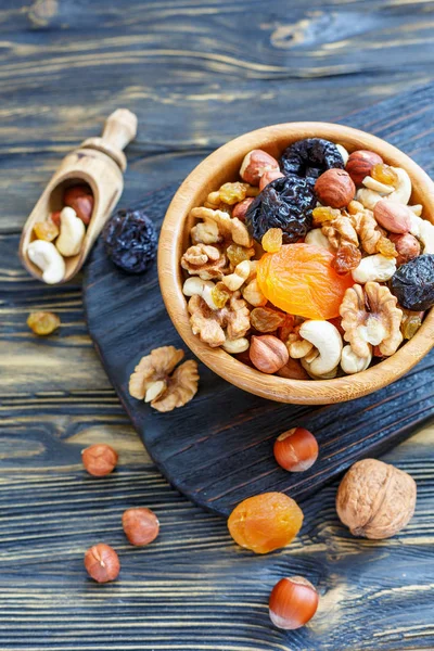 Mixture of nuts and dried fruit in a wooden bowl.