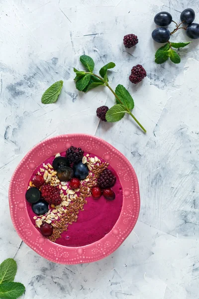 Smoothie bowl with red beets, berries and flax seeds.