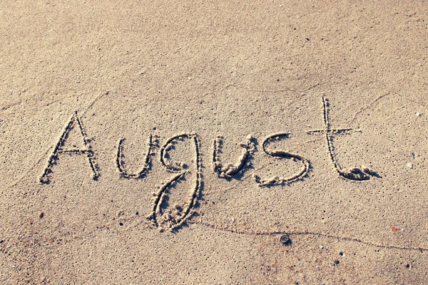 AUGUST на ніжному пляжному піску — стокове фото