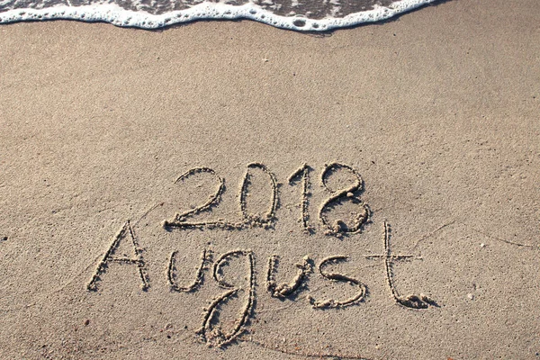 Inscriptie augustus op strand zand — Stockfoto
