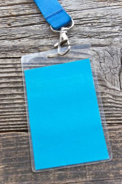 Blank ID card tag on wooden background clipart