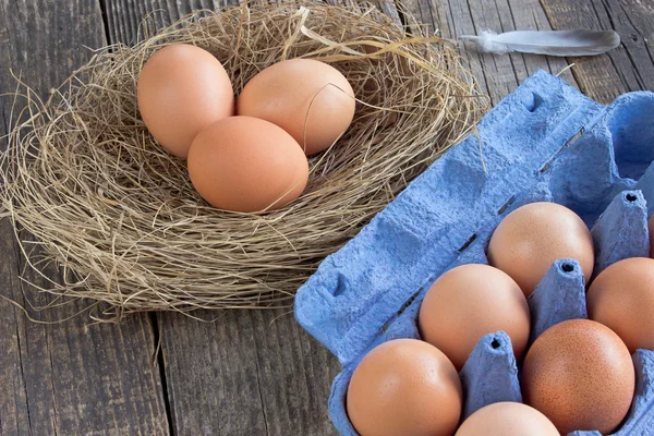 Eggs in nest and cardboard package — Stock Photo, Image