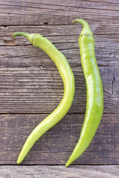 Zelená hot chili papričky na dřevěné pozadí — Stock fotografie