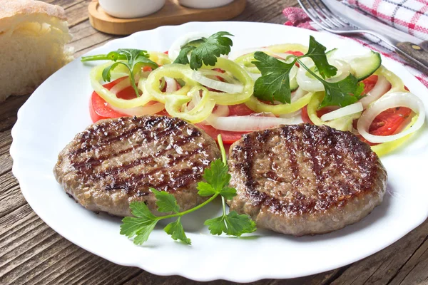 Hambúrguer em prato com salada de legumes — Fotografia de Stock