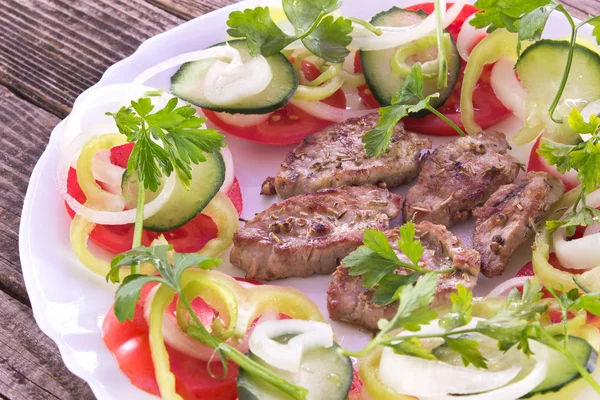 Carne de porco grelhada e legumes em prato — Fotografia de Stock