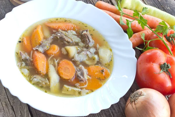 Говядина и овощной суп в тарелке на деревянном столе — стоковое фото