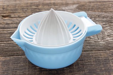 Ahşap arka plan üzerinde plastik limon sıkacağı