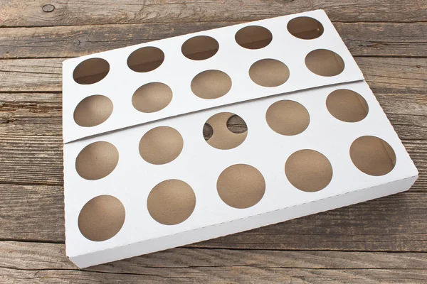 Scatola di cartone con fori su sfondo di legno — Foto Stock