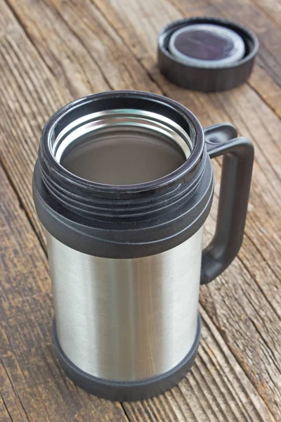 Thermos flask mug with lid on wooden table — Stock Photo, Image
