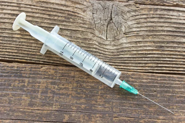 Syringe op houten achtergrond — Stockfoto
