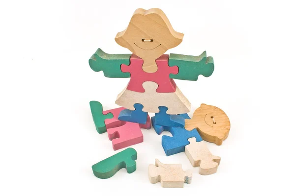Menina de madeira colorida de pé em peças de quebra-cabeça menino isolado em w — Fotografia de Stock