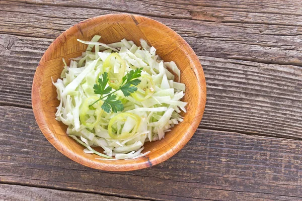 Sliced young cabbage salad in bamboo bowl on table — Stock Photo, Image