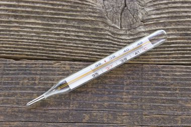 Eski ahşap arka plan üzerinde tıbbi termometre