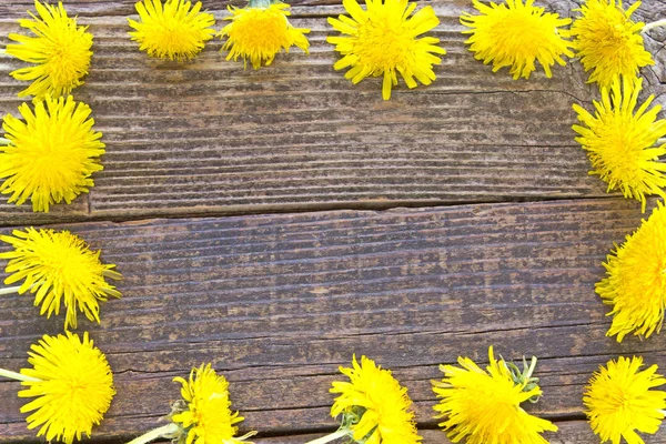 Eski ahşap zemin üzerine karahindiba çiçekli çerçeve