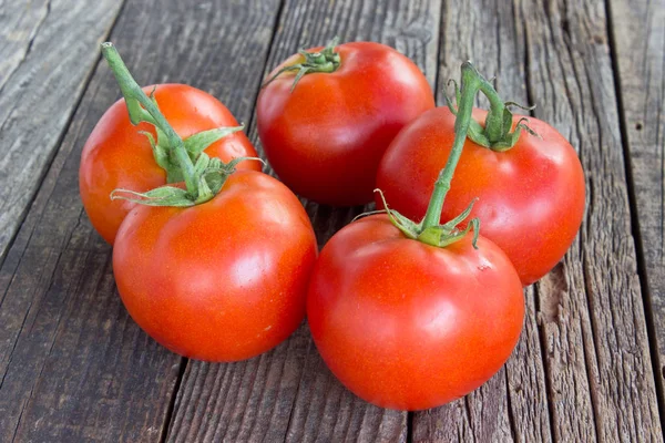 Tomato on old wooden background — Stock Photo, Image