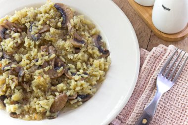 Çatal ile plaka üzerinde mantarlı risotto