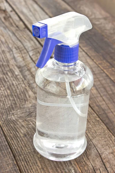 Blaue Kunststoff-Sprühflasche für Pflanzen auf Holzgrund — Stockfoto