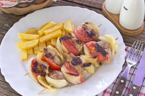 Carne grelhada com legumes em paus na placa na mesa — Fotografia de Stock