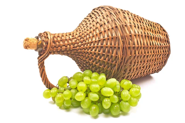 Uva bianca con vecchia bottiglia di vetro di vimini avvolto isolato su wh — Foto Stock