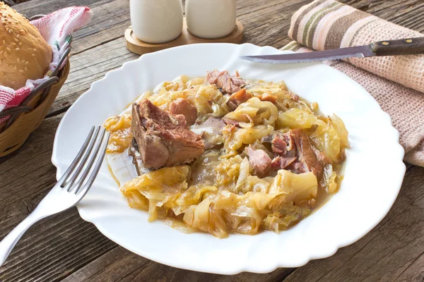 Sauerkraut mit geräuchertem Schweinefleisch auf Holztisch — Stockfoto