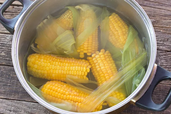 나무 테이블에 냄비에 옥수수 cobs 요리 — 스톡 사진