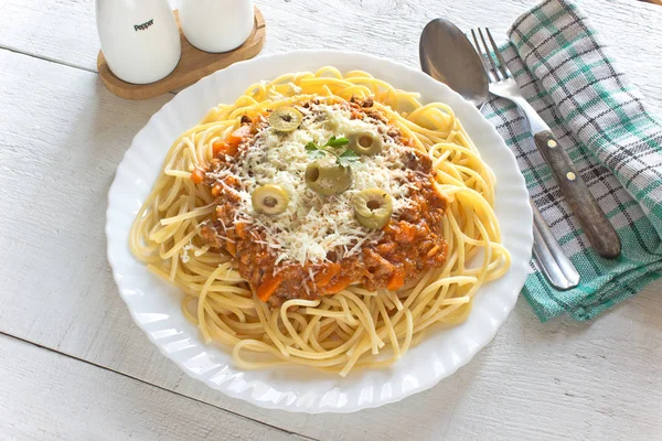 Spaghetti bolognese in plate on wooden table — Stock Photo, Image