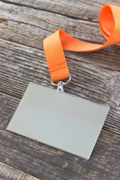 Blank ID card tag with ribbon on wooden background — Stock Photo, Image