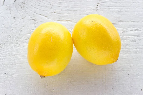 Dos limones sobre fondo de madera blanca — Foto de Stock
