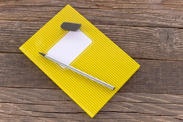 Caderno com lápis e borracha sobre fundo de madeira — Fotografia de Stock