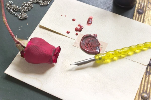 Wax sealed love letter with rose and pen on vintage background