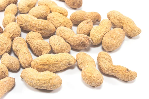 Erdnüsse im Muschelhaufen auf weißem Hintergrund — Stockfoto