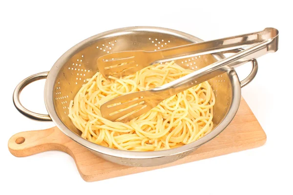 Fresh cooked spaghetti in strainer with serving tongs isolated o — Stock Photo, Image