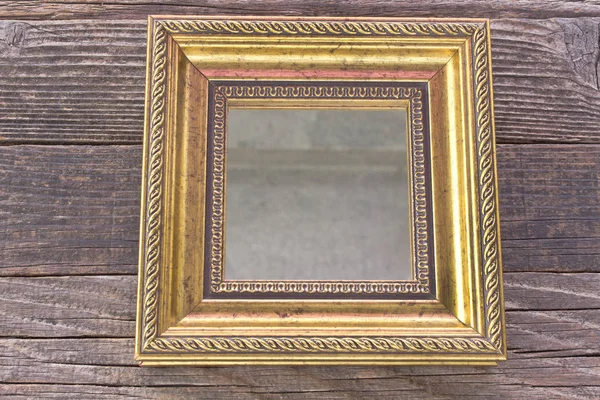 Χρυσό καθρέφτη με μπαρόκ καρέ σε φόντο ξύλινη — Φωτογραφία Αρχείου