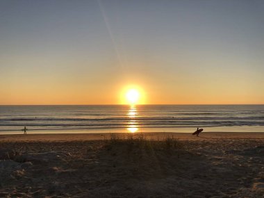 Portekiz 'in Costa da Caparica plajında gün batımı