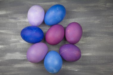 Gri arkaplanda mavi ve mor Paskalya yumurtaları