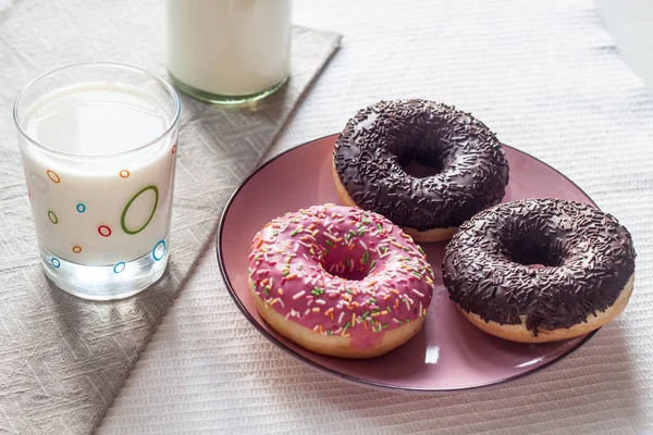 Donuts rosa e chocolate em um prato rosa . — Fotografia de Stock