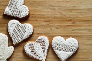 Ahşap arka plan üzerinde bir kalp şeklinde beyaz Sevgililer günü kurabiyeleri