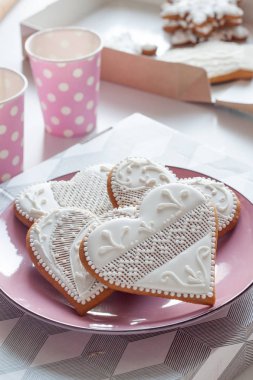 Pembe bir plaka üzerinde bir kalp şeklinde beyaz kurabiye