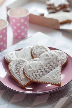 White gingerbread on a plate for Valentine's Day on white table