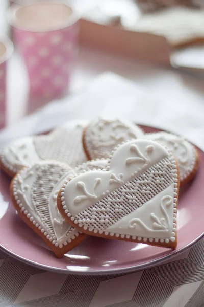 Bílá sušenky ve tvaru srdce na růžové desky — Stock fotografie