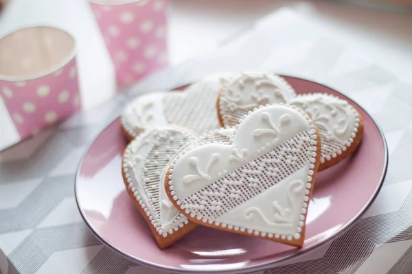 Pan de jengibre blanco en forma de corazón en un plato rosado para el día de San Valentín — Foto de Stock