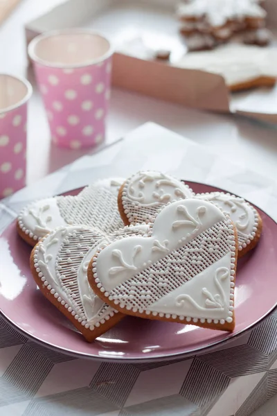 Weiße Lebkuchen auf einem Teller zum Valentinstag auf weißem Tisch lizenzfreie Stockbilder