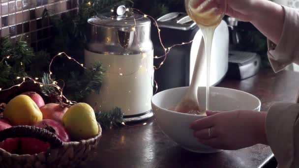 Female cook adds honey to flour — Stock Video