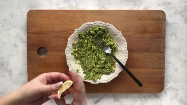 Cooking avocado puree with lemon juice — Stock Video