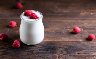 Beyaz cam kase içinde ahududu Yoğurtlu.