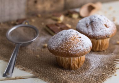 Jüt ve Beyaz ahşap zemin üzerine şeker tarafından toz muffins.