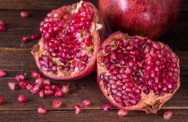 Kırmızı nar rustik ahşap masanın üzerine dilimlenmiş.