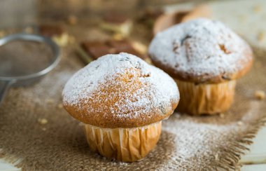 Jüt ve Beyaz ahşap zemin üzerine şeker tarafından toz muffins.