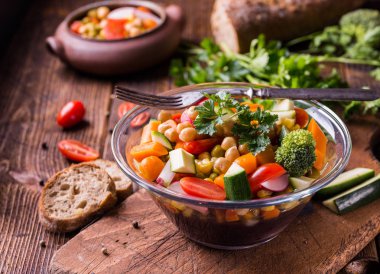 Brokoli ve koyu ahşap masa üzerinde domates cam kase sebze salatası.