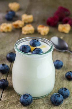 Rustik masada cam kapta yaban mersini ile beyaz yoğurt.
